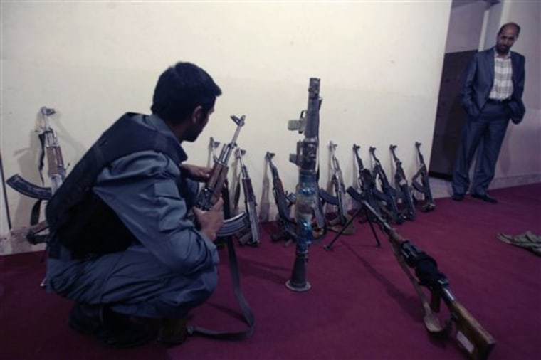 Afghan policemen sort out weapons recently confiscated from disbanded private security companies in Herat, west of Kabul, Afghanistan, on Wednesday.